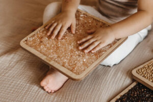 dziecko bawi się panelami sensorycznymi z solą firmy Hajo Kids