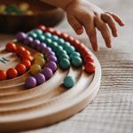 dziecko bawi się tęczą montessori do wysypywania