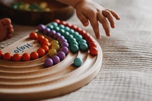dziecko bawi się tęczą montessori do wysypywania