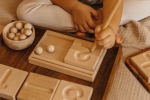 dziecko liczy z pomocą drewnianych pomocy Hajo Kids