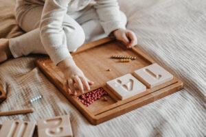 Dziecko uczy się liczyć metodą montessori z użyciem pomocy Hajo kids