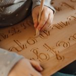 Drewniany alfabet żłobiony litery pisane małe firmy Hajo Kids w formie tablicy grafomotorycznej dla dzieci