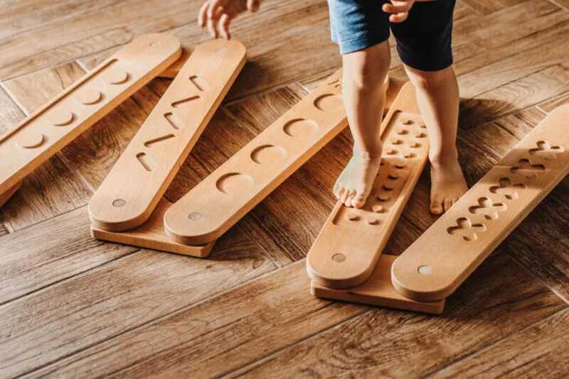 Drewniana równoważnia sensoryczna Montessori – dziecko ćwiczy równowagę i integrację sensoryczną