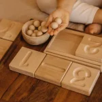 dziecko uczy sie liczyć z drewnianymi zabawkami edukacyjnymi montessori