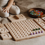 dziecko uczy sić liczyć dzieki drewnianym pomocom eduukacyjnym