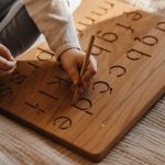 dziecko uczy się pisać na tablicy grafomotorycznej