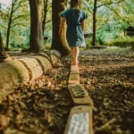 dziecko chodzi boso po drewnianej równoważni sensorycznej Hajo Kids