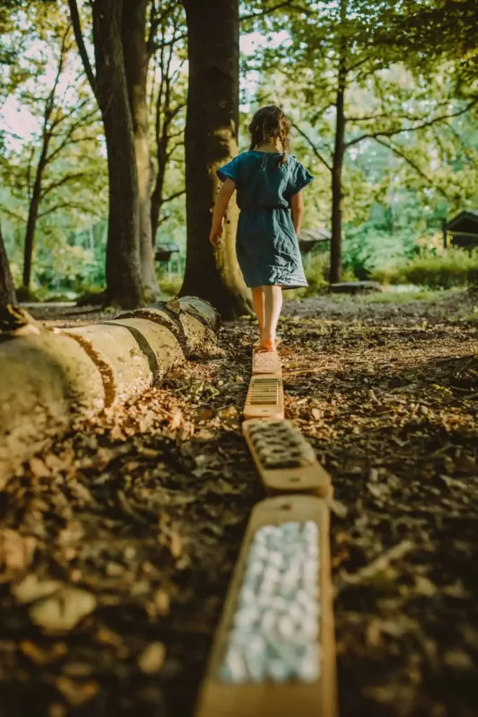 dziecko chodzi boso po drewnianej równoważni sensorycznej Hajo Kids